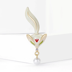 Elegant fox enamel brooch with pearl pendant on a minimalist white display stand