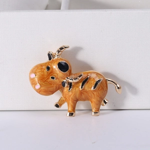 Macro d'une broche boeuf en alliage doré avec détails en émail à texture marbrée