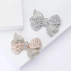 Elegant bow brooches with rhinestones and pearls in silver and gold finishes