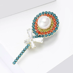 Detailed view of rhinestone lollipop brooch with white pearl and blue crystal bow