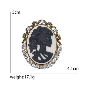 Retro gothic skull cameo brooch with green gemstone eye and rhinestone border 5cm
