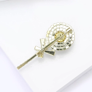 Detailed back view of golden lollipop brooch showing the pin clasp and metal structure