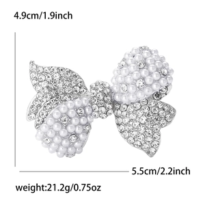 Detail view of rhinestone and pearl bow brooch with dimensions 4.9cm by 5.5cm