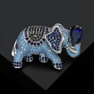 Close-up of elephant brooch with blue zircons holding a pear-shaped gemstone