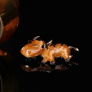Vue détaillée de la broche vache vintage avec émail orange et finitions dorées