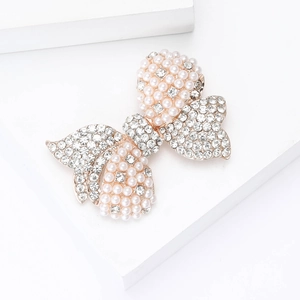 Close-up of bow brooch featuring pearls and rhinestones on a gold alloy base