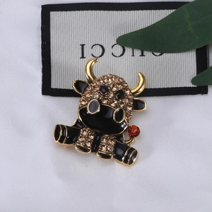 Spilla a forma di mucca in smalto nero e strass ambrati su lega dorata