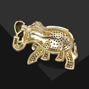 Detail view of gold elephant brooch back with honeycomb hollow design and green stone