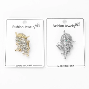 Detailed view of rhinestone animal brooches in gold and silver with green gem eyes