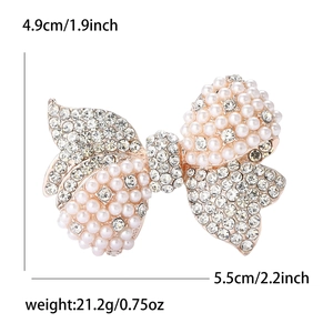 Elegant rhinestone and pearl bow brooch with dimensions 5.5cm width and 4.9cm height