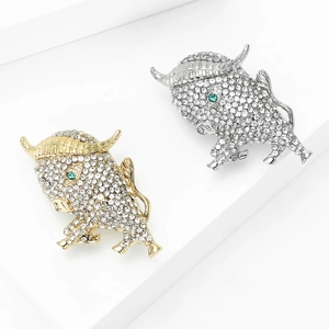 Elegant gold and silver bull brooches encrusted with crystals and emerald green eyes
