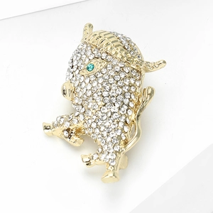 Elegant gold calf brooch with sparkling crystals and emerald eye on white background