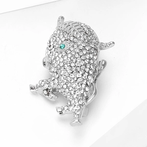 Detailed view of luxury ox brooch with sparkling crystal pavé and green stone eyes