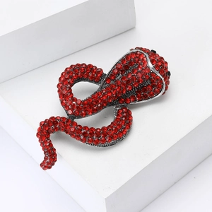 Close-up of a vintage red rhinestone cobra brooch with detailed silver-tone alloy setting