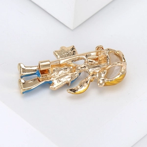 Detail view showing the sturdy golden metal pin clasp mechanism on a cat-eye brooch