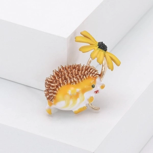 Cartoon hedgehog brooch with yellow flower detail and gold-plated alloy finish