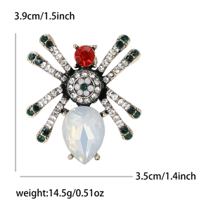 Vintage spider brooch with red opal stones and green rhinestones in an alloy base