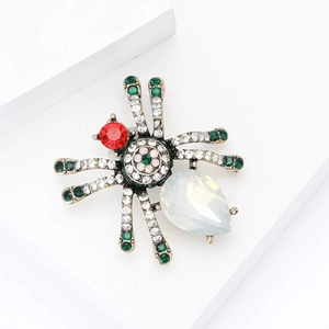 Vintage gold alloy spider brooch with red gemstone head and opal-like water drop body