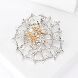 Détail de la broche toile d'araignée vintage avec araignée dorée et strass blancs