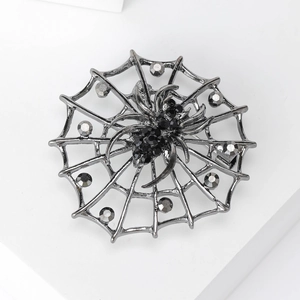 Détail macro d'une broche toile d'araignée gothique avec cristaux noirs sur socle blanc