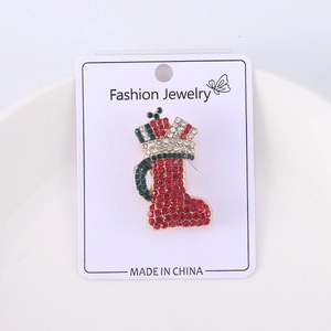 Detail of Christmas boot brooch with red, green and white rhinestones on gold alloy