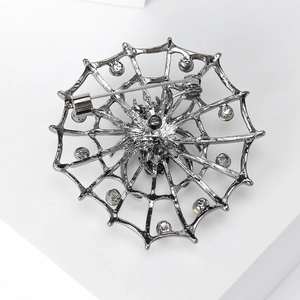 Broche toile d'araignée rétro en métal noir avec détail d'épingle de sûreté sur fond blanc
