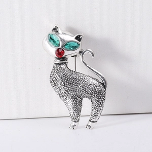 Macro shot of retro cat brooch with green crystal eyes and silver alloy texture