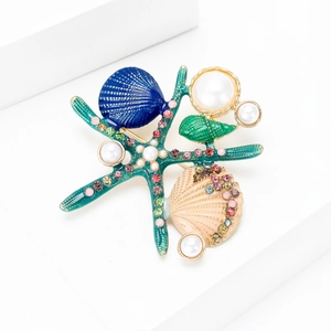 Détail de la broche étoile de mer en émail avec coquillages, perles et strass