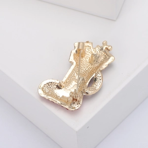 Back view of gold Christmas boot brooch showing textured alloy finish and secure pin