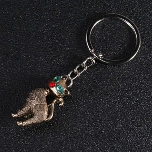 Macro detail of retro cat brooch with green crystal eyes and antique gold finish