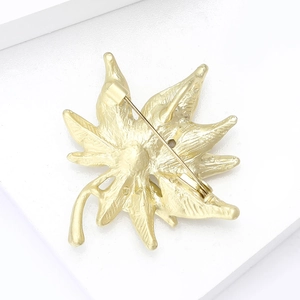 Detailansicht der Rückseite der goldenen Ahornblatt-Brosche mit Sicherheitsnadel-Verschluss