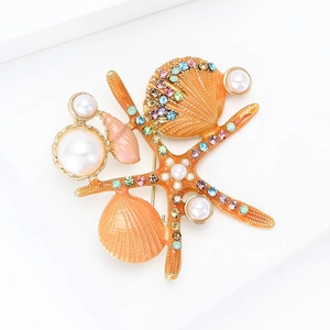 Détails macro d'une broche étoile de mer et coquillage avec strass et perles blanches