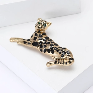 Eleganter Gold-Leopard-Anstecknadel mit schwarzer Emaille und grünen Augen auf weißem Sockel