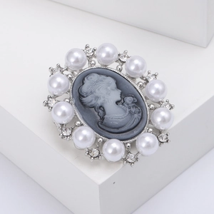Vintage relief brooch with lady cameo design, white pearls, and rhinestones on silver base