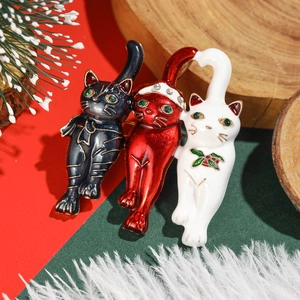 Three Christmas cat brooches in black, red and white with alloy enamel and green gemstones