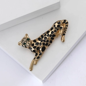 Detailansicht der Leoparden-Brosche mit Goldfinish, Emaille-Punkten und grünen Edelsteinaugen