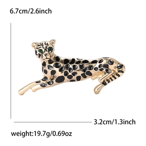 Goldene Leopardenbrosche mit schwarzer Emaille und grünen Edelsteinaugen auf Weiß