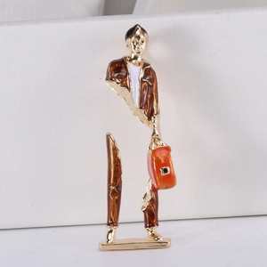Makro-Detail einer Emaille-Brosche mit moderner kreativer Figur und goldenen Kanten