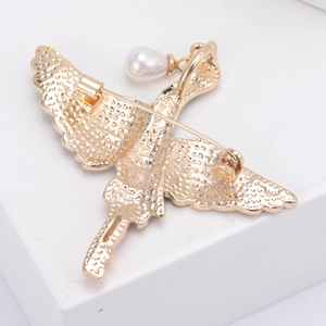 Détail de la broche oiseau dorée avec épingle de sûreté et perle suspendue