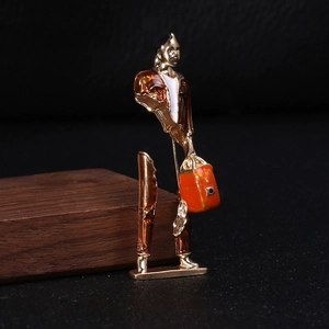 Künstlerische goldene Brosche mit Emaille zeigt eine surrealistische Figur im Mantel