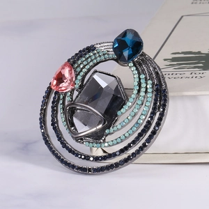 Vintage alloy brooch with hexagon gray stone and colorful crystals on white book