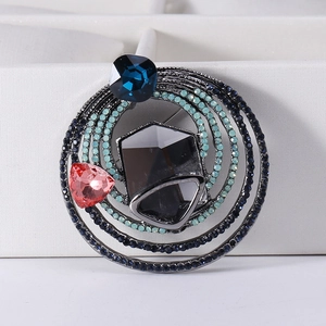 Macro detail of alloy brooch with layered rings and embedded multicolored crystals