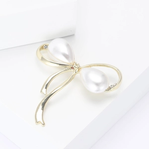 Élégante broche nœud dorée avec perles blanches en forme de goutte et cristaux brillants