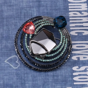Detail of vintage round brooch featuring heart pink crystal and blue rhinestones on alloy base