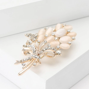 Elegant gold bouquet brooch with white opal petals and sparkling crystal ribbon accent