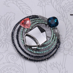 Detailed close-up of a vintage crystal brooch featuring multi-colored geometric stones