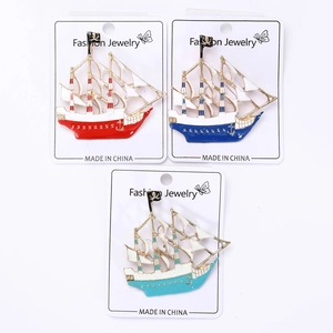 Set of three colorful enamel pirate ship brooches with Jolly Roger flags on card