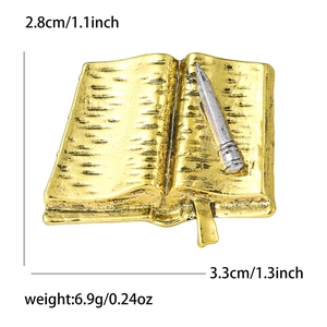 Macro detail of retro alloy open book brooch with pencil showing 2.8cm by 3.3cm dimensions