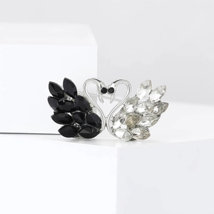 Close-up of elegant black and white double swan brooch with crystal rhinestones