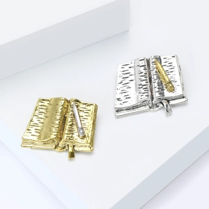 Vintage metal book shaped brooches in gold and silver finish with textured paper detail